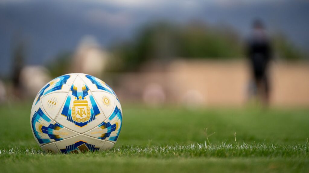 Bola de futebol sobre gramado verde, representando os termos e glossário da Copa do Mundo 2026